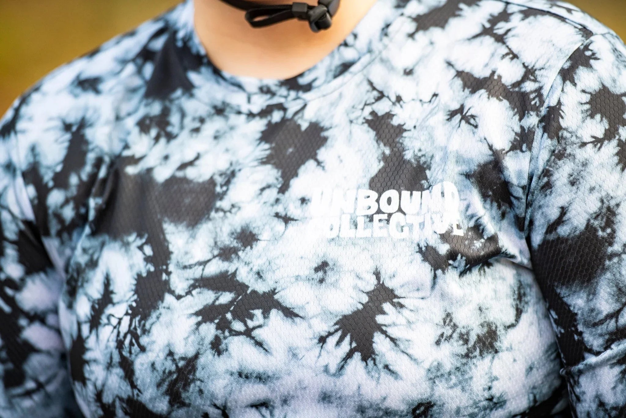 Close-up of a women’s Unbound Collective mountain bike jersey in black and white smoke tie-dye pattern