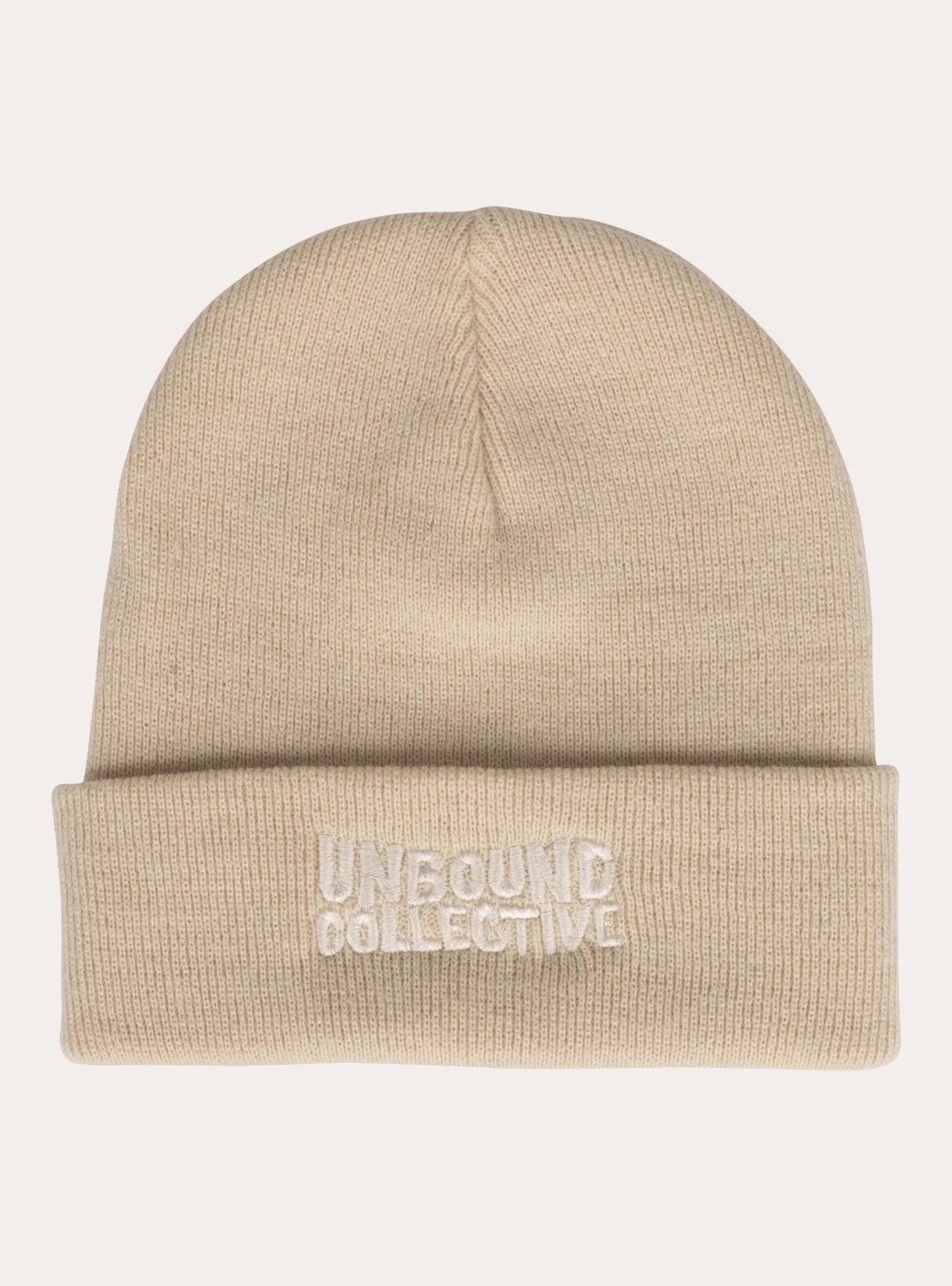 Beige knit beanie hat with folded cuff and embroidered Unbound Collective logo, sustainable mountain bike apparel