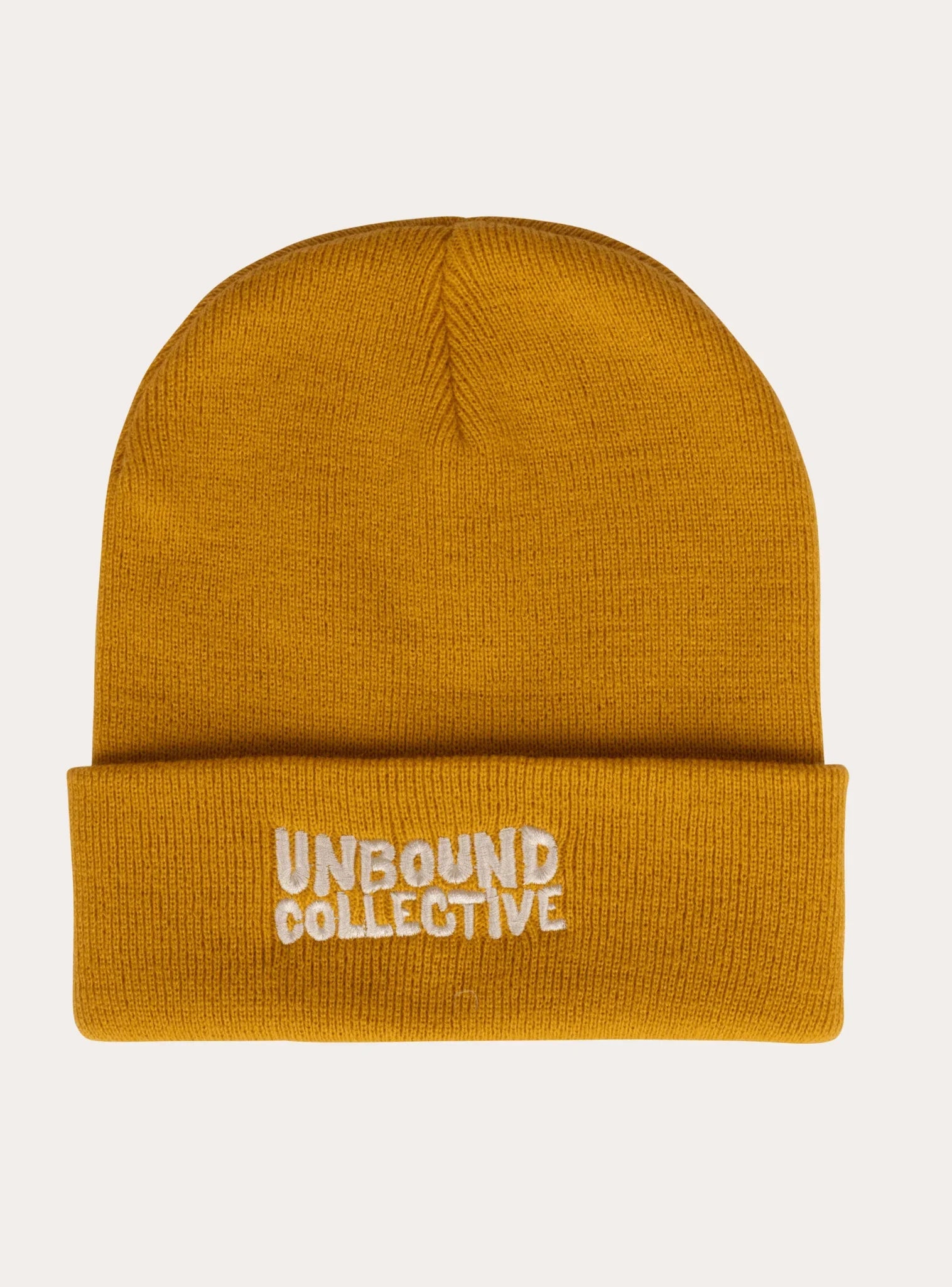 Mustard yellow knit beanie hat with folded cuff and white embroidered Unbound Collective logo