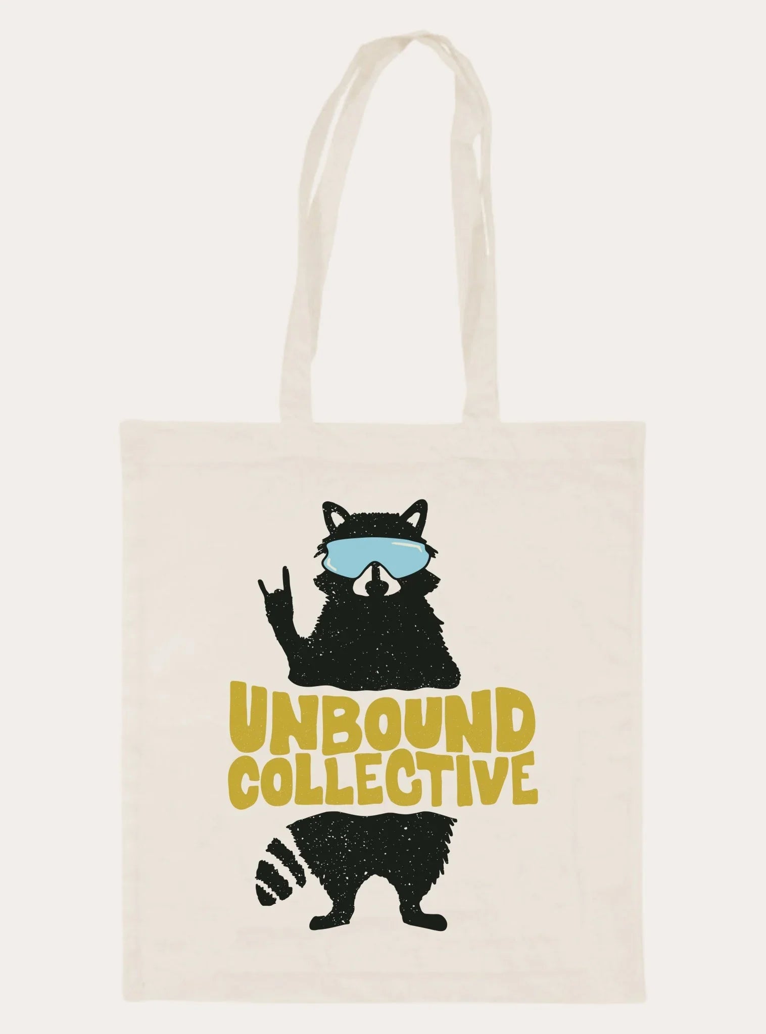 White tote bag with graphic of raccoon wearing blue goggles and text 'Unbound Collective' in mustard yellow